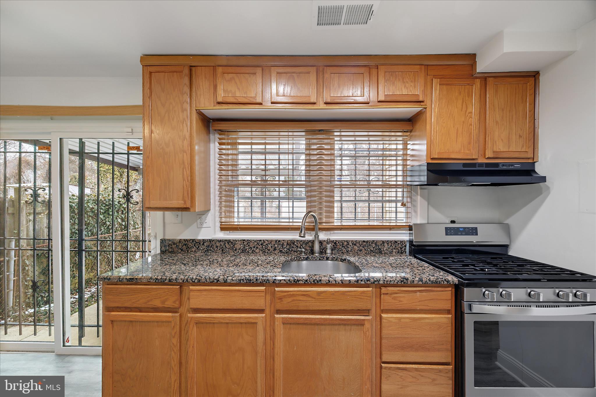 5600 Walker Mill Road Capitol Heights, MD 20743 - Photo 12 of 30 a kitchen with granite countertop a stove a sink and a cabinets