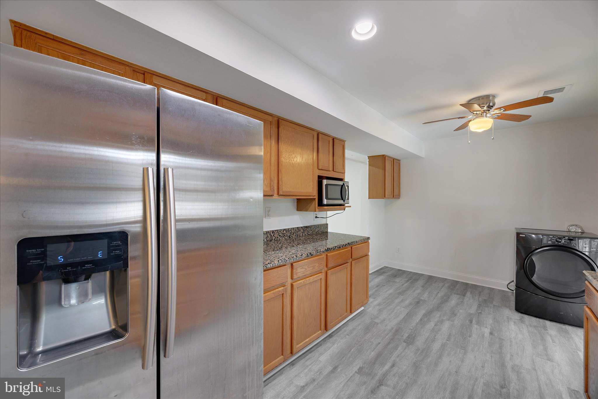5600 Walker Mill Road Capitol Heights, MD 20743 - Photo 13 of 30 a kitchen with stainless steel appliances granite countertop a refrigerator a stove and a sink with wooden floor