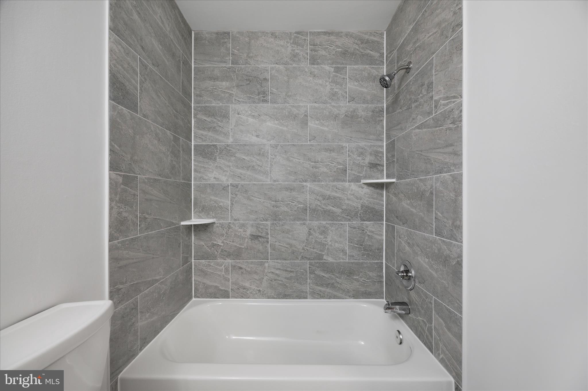 5600 Walker Mill Road Capitol Heights, MD 20743 - Photo 25 of 30 a bath tub sitting next to a white toilet and sink