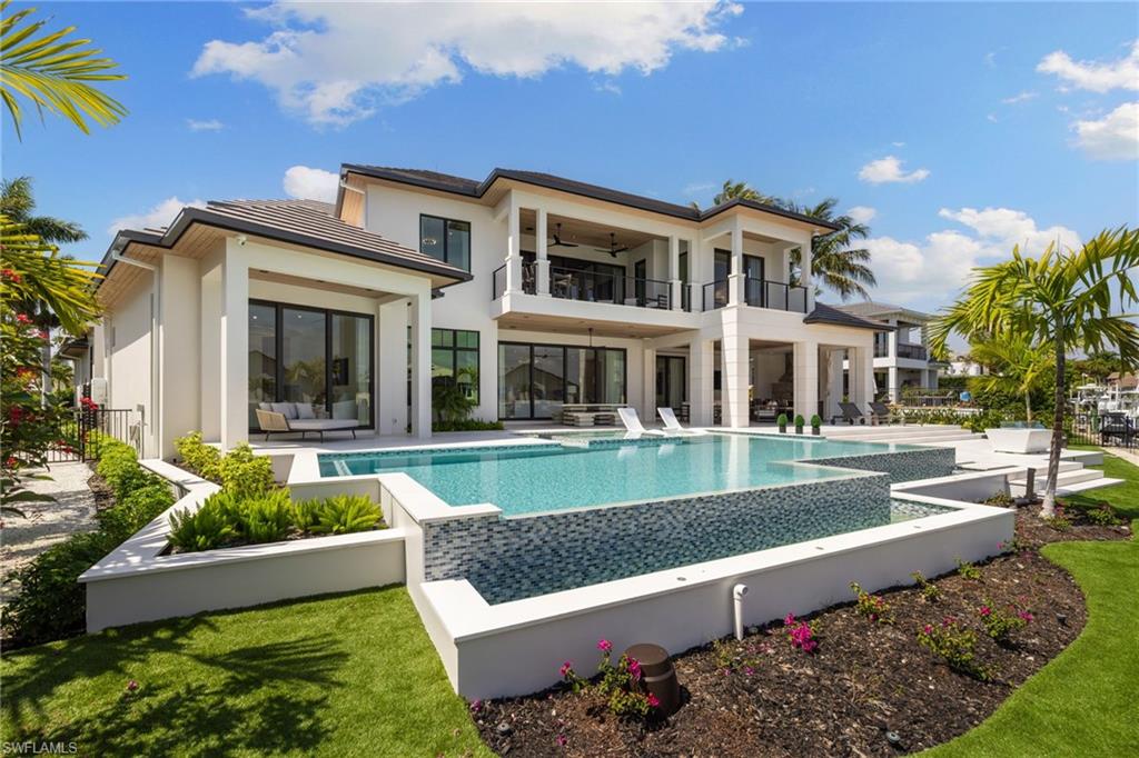 2345 Tarpon Road Naples, FL 34102 - Photo 35 of 43 Rear view of house with an infinity pool, a patio area, ceiling fan, and a balcony