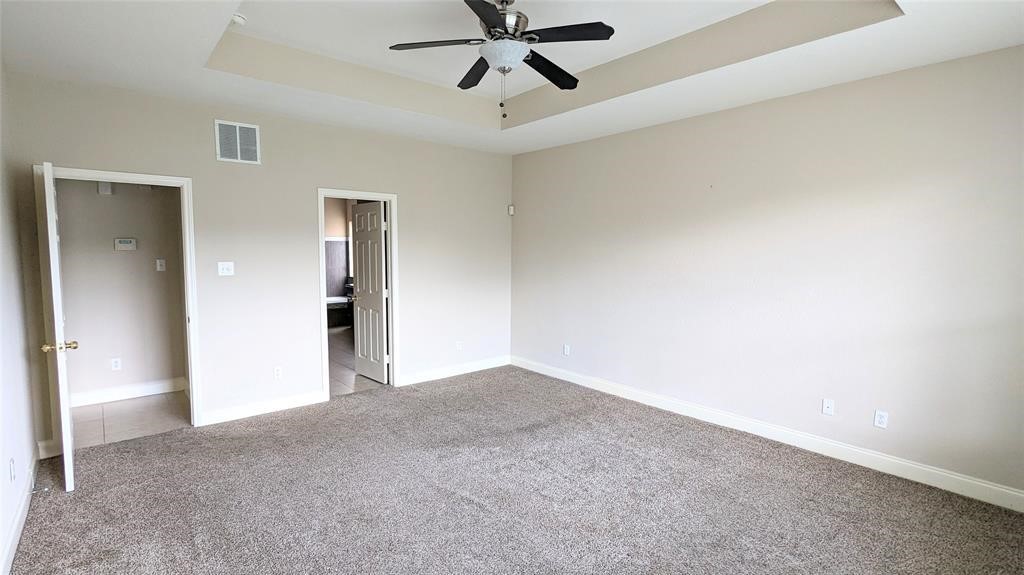 20909 Springport Court Katy, TX 77450 - Photo 16 of 39 Spacious bedroom featuring plush carpeting, neutral walls, and a ceiling fan, offering comfort and style.