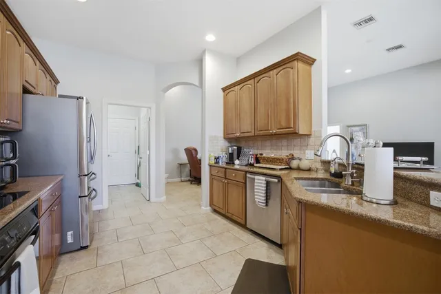 a kitchen with stainless steel appliances granite countertop a sink stove and cabinets