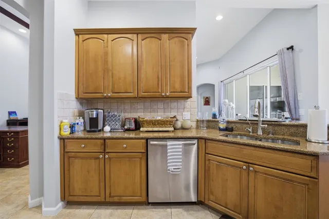 a kitchen with stainless steel appliances granite countertop a refrigerator a stove a sink and a microwave