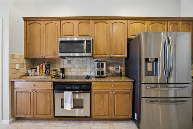a kitchen with stainless steel appliances granite countertop a refrigerator and a stove top oven