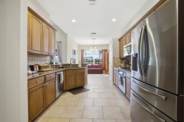 a kitchen with stainless steel appliances granite countertop a refrigerator sink and cabinets