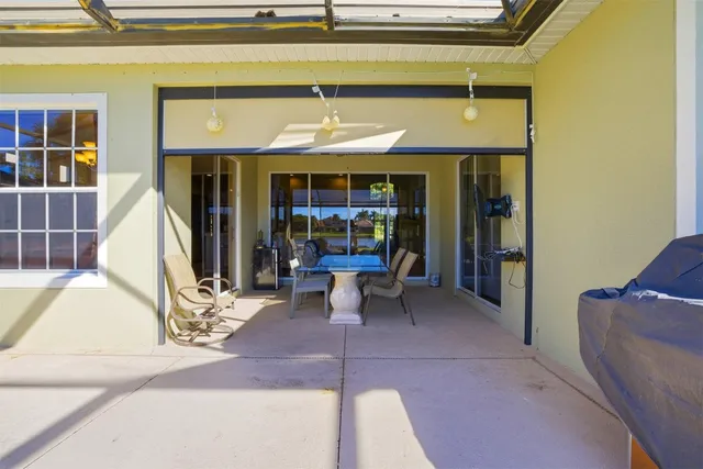 a view of a backyard with swimming pool and sitting area