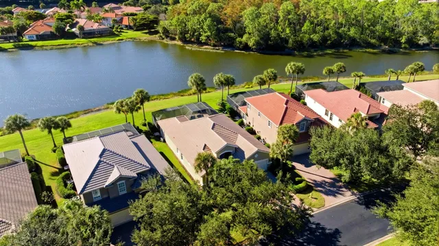 an aerial view of a house with swimming pool and large trees