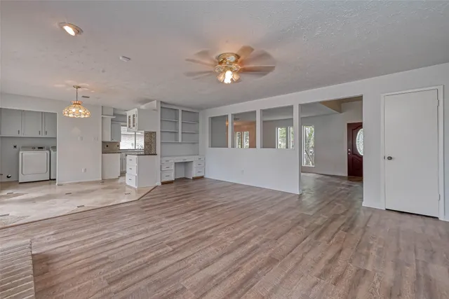 a view of an empty room with a fireplace and a window