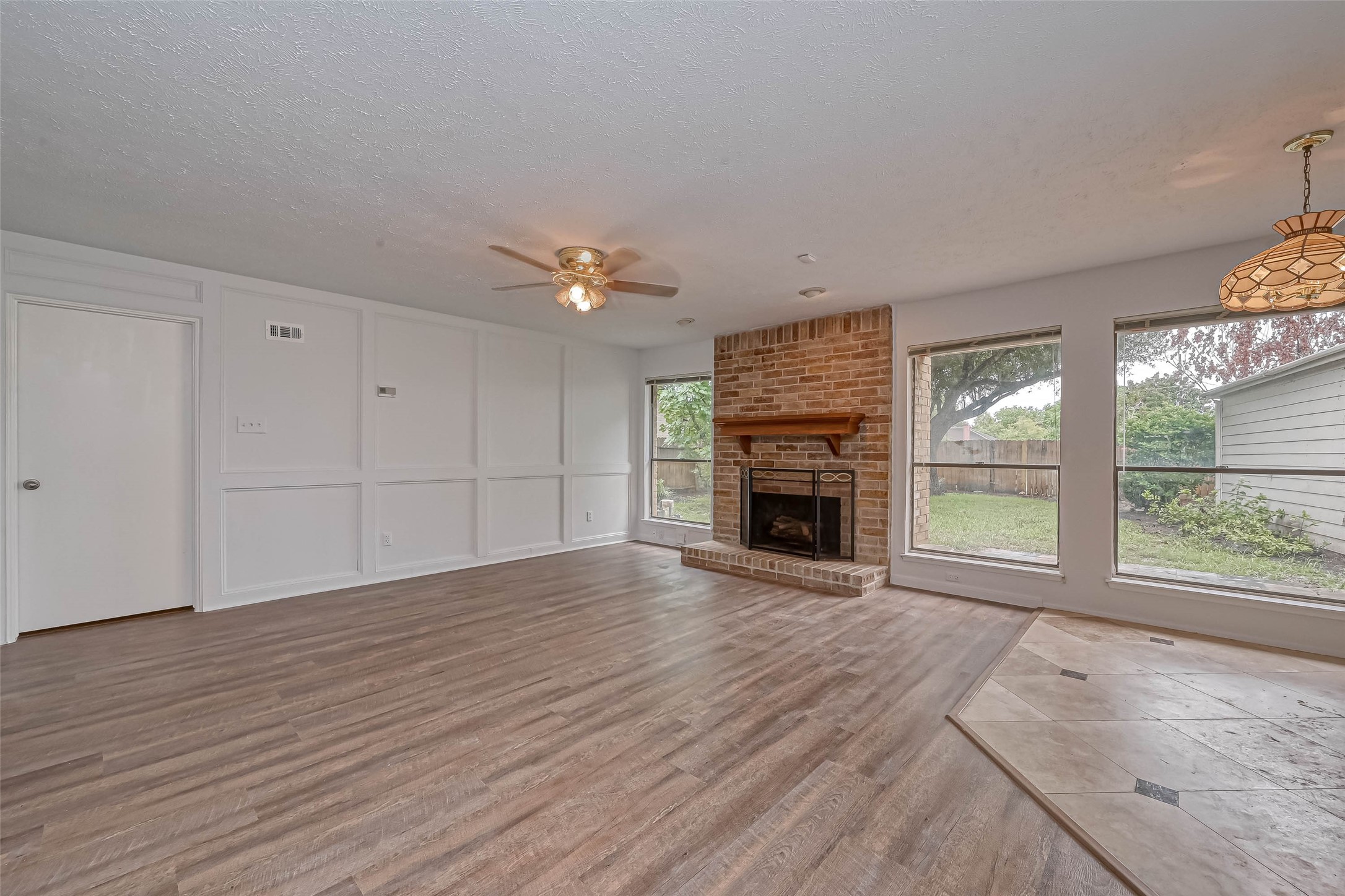 2831 Pecan Ridge Drive Sugar Land, TX 77479 - Photo 10 of 44 an empty room with wooden floor fireplace and windows