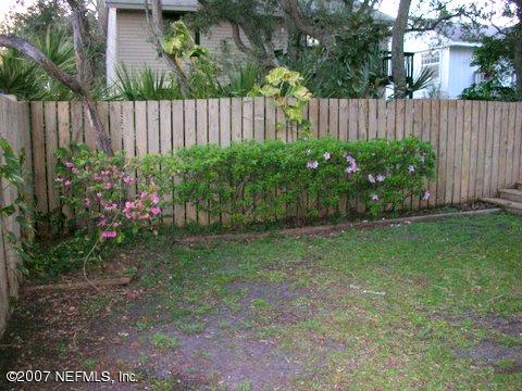 1150 Penman Road Jacksonville Beach, FL 32250 - Photo 4 of 16 a view of a backyard with plants and wooden fence