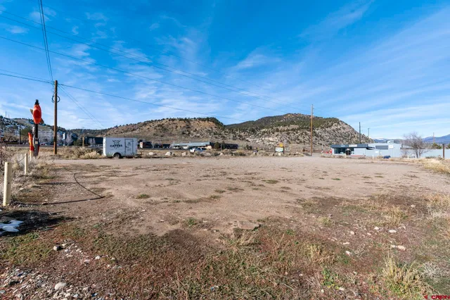 a view of a dry yard with wooden fence