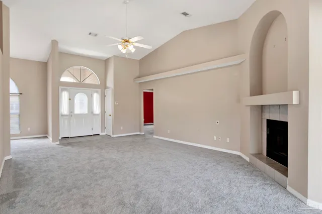 a view of an empty room with a fireplace and a window