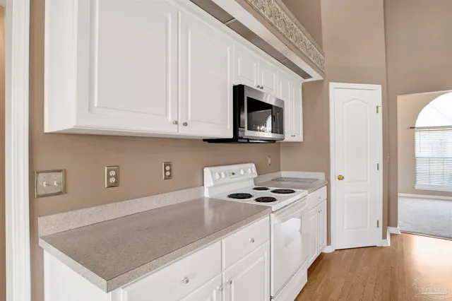 a kitchen with stainless steel appliances granite countertop a sink a stove microwave and cabinets