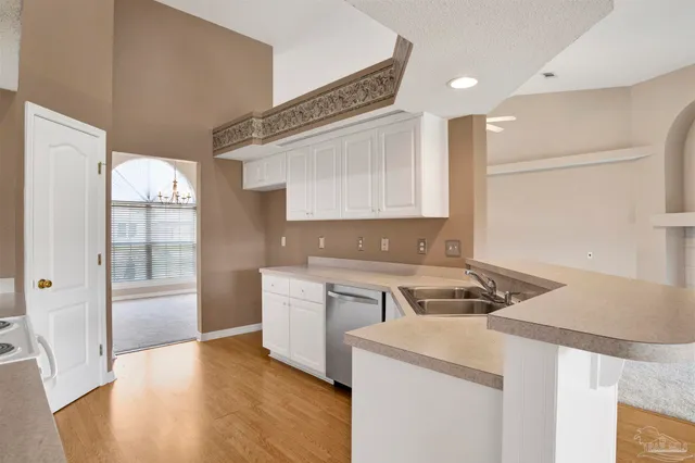 a kitchen that has a sink a stove and wooden floor