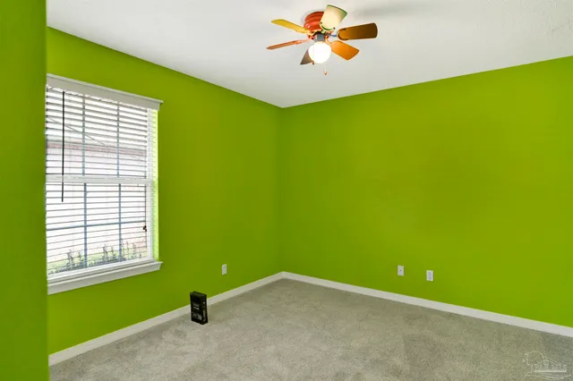 a view of a big room with windows and chandelier fan