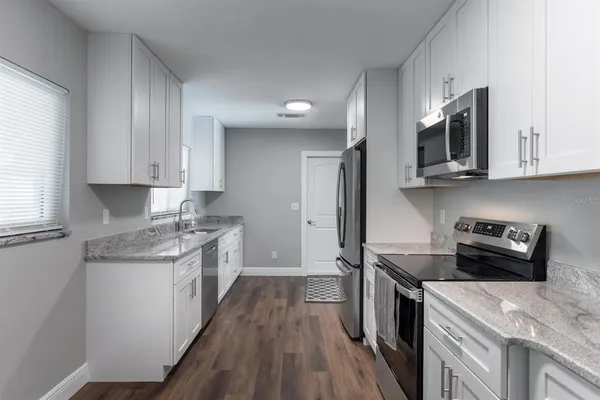 a kitchen with stainless steel appliances granite countertop wooden cabinets sink stove and refrigerator