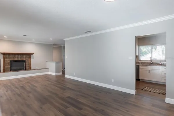 a view of an empty room with a fireplace and a window