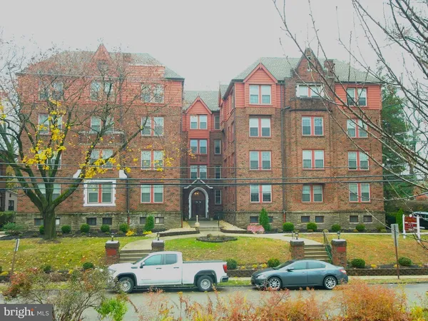 a view of a big building with a big yard and large trees