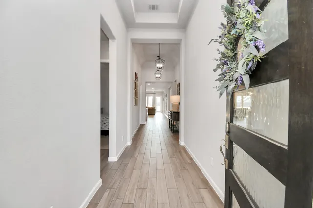 a view of a hallway with wooden floor and staircase