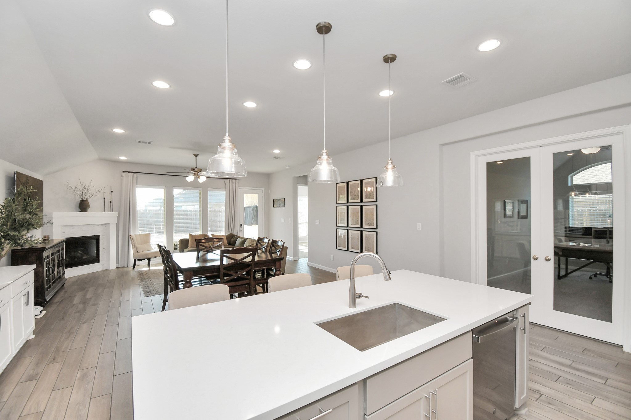 10522 Rigel Rdg Way Richmond, TX 77406 - Photo 7 of 41 a kitchen with a sink dishwasher a dining table and chairs with wooden floor
