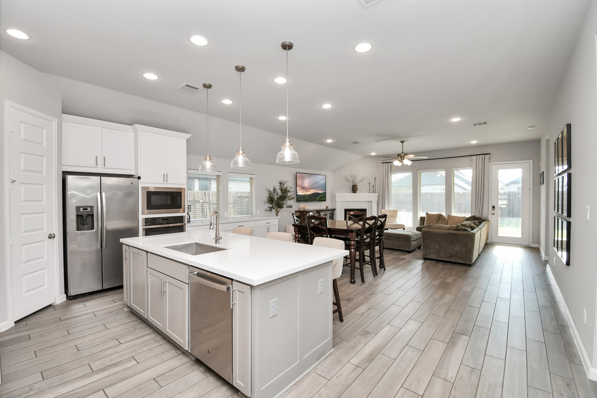 10522 Rigel Rdg Way Richmond, TX 77406 - Photo 9 of 41 a large white kitchen with a large kitchen island white cabinetry and stainless steel appliances
