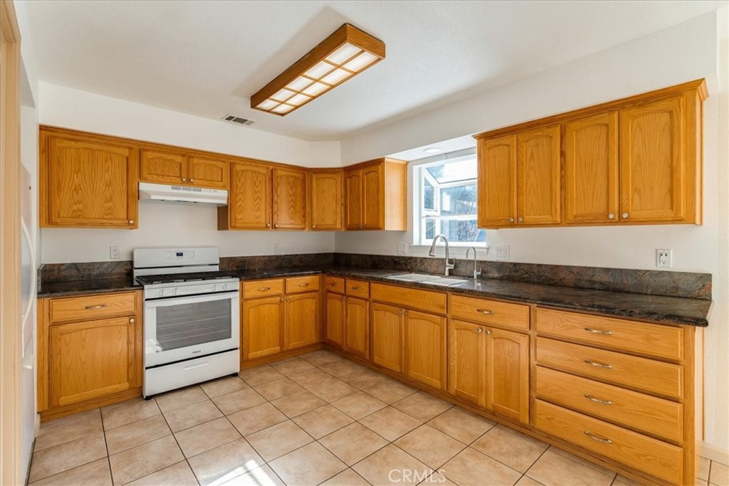 9305 Santa Lucia Road Atascadero, CA 93422 - Photo 11 of 41 a kitchen with granite countertop cabinets stainless steel appliances a sink and a window