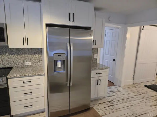 a dining room with wooden floor a chandelier a wooden table and chairs