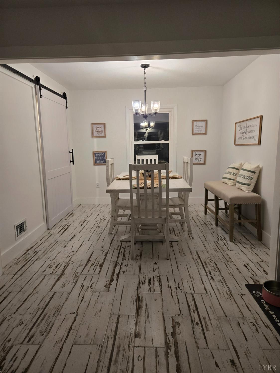 4015 White House Road Moneta, VA 24121 - Photo 21 of 35 a dining room with wooden floor a chandelier a wooden table and chairs