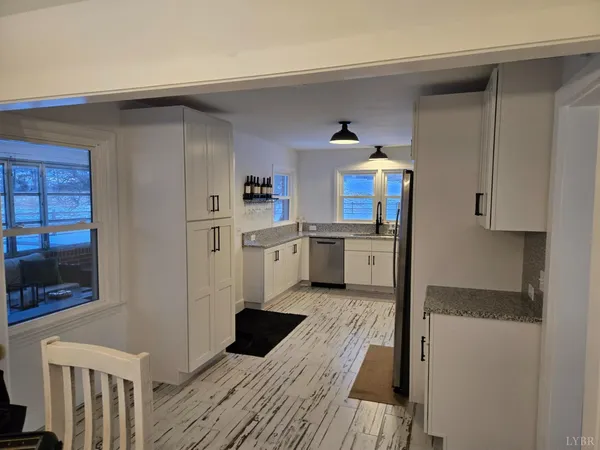 a kitchen with granite countertop white cabinets stainless steel appliances and a sink
