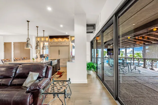 a kitchen with stainless steel appliances granite countertop a sink a stove and chairs