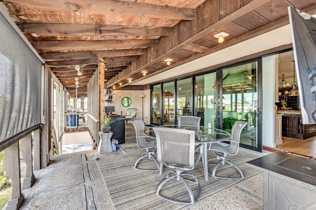 a view of a hallway with wooden floor and a bathroom