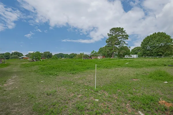 a view of a field with grass and a small yard