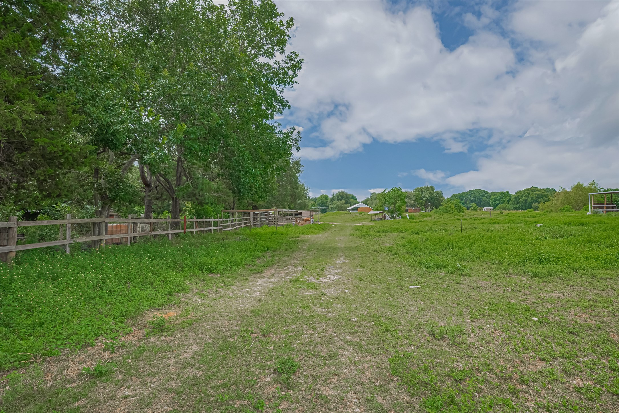35535 Windmill Road Hempstead, TX 77445 - Photo 14 of 41 Expansive rural property with open green fields, a clear pathway, and surrounding trees. Ideal for those seeking tranquility and space.