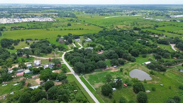 an aerial view of residential house with outdoor space and trees all around