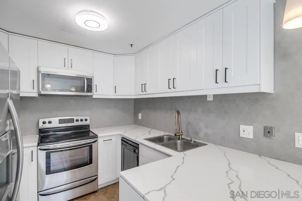 5645 Friars Road, Unit 363 San Diego, CA 92110 - Photo 14 of 74 a kitchen with white cabinets and appliances