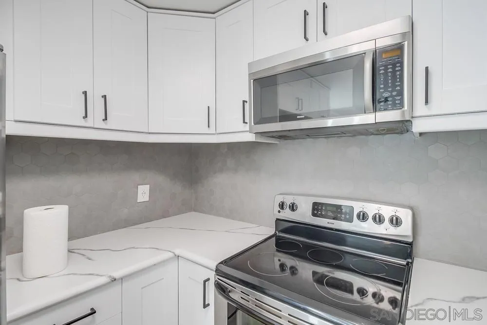 5645 Friars Road, Unit 363 San Diego, CA 92110 - Photo 15 of 74 a kitchen with a stove and white cabinets