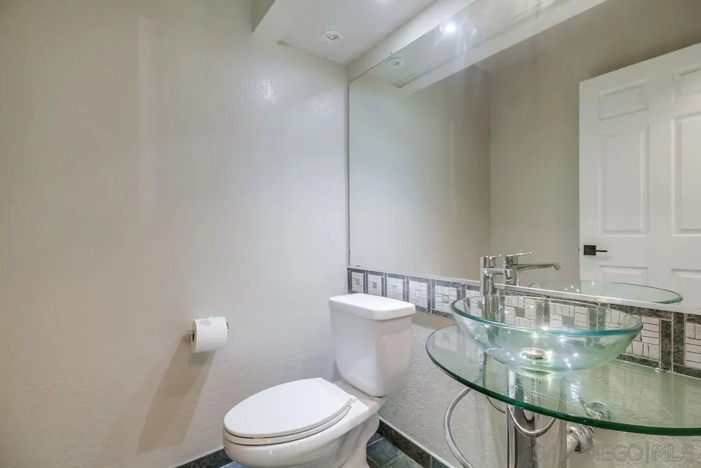 5645 Friars Road, Unit 363 San Diego, CA 92110 - Photo 38 of 74 a bathroom with a granite countertop sink a toilet and a mirror