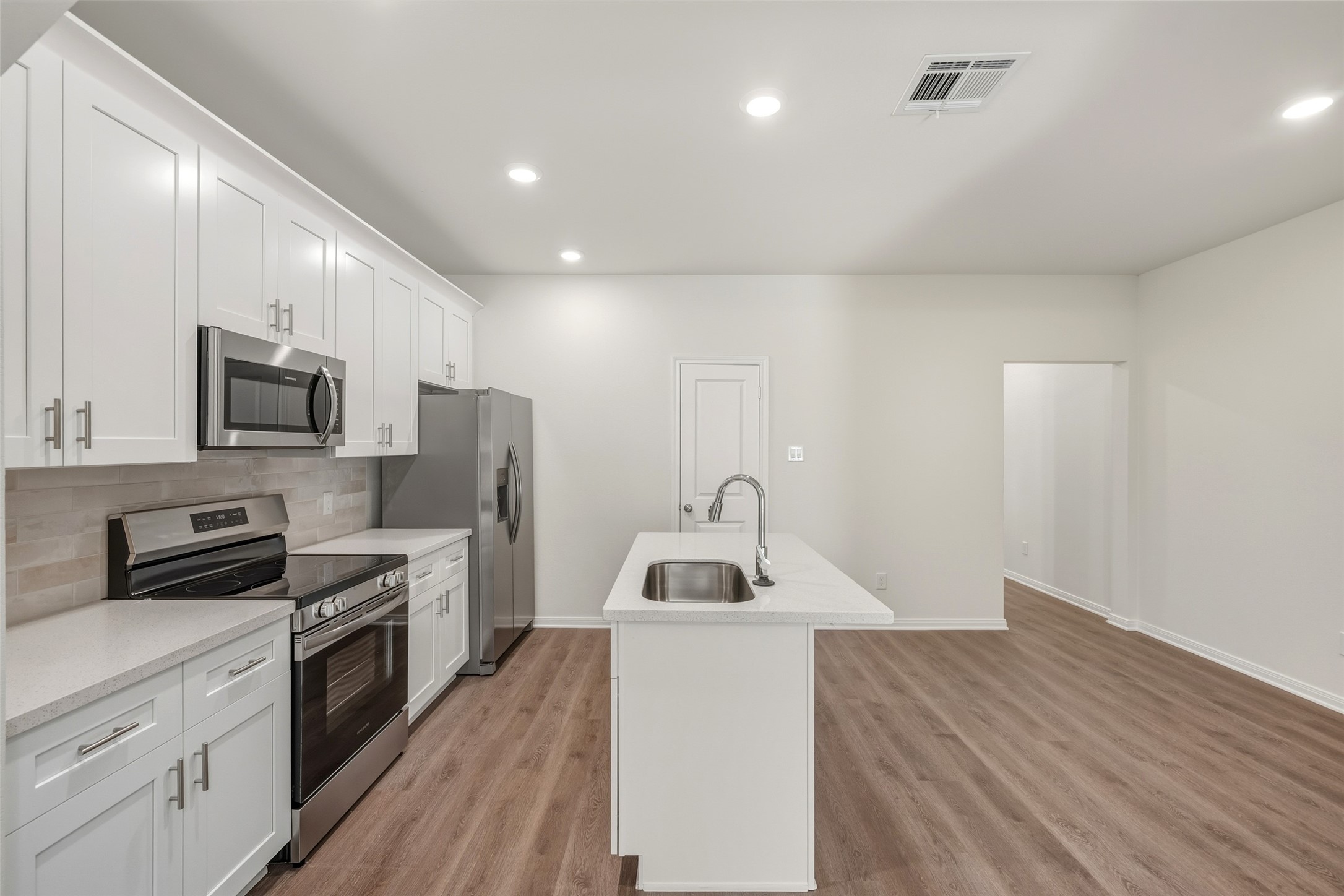 710 West Dallas Street Conroe, TX 77301 - Photo 6 of 19 a kitchen with sink a microwave and cabinets