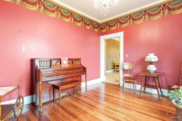 a view of a room with wooden floor and furniture