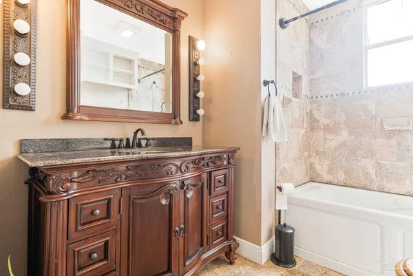 a bathroom with a granite countertop sink a toilet a mirror and shower