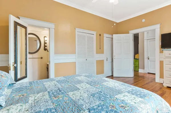 a bedroom with a bed closet and a flat tv screen