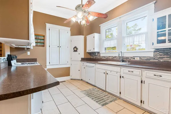 a large kitchen with kitchen island granite countertop a sink white cabinets and window