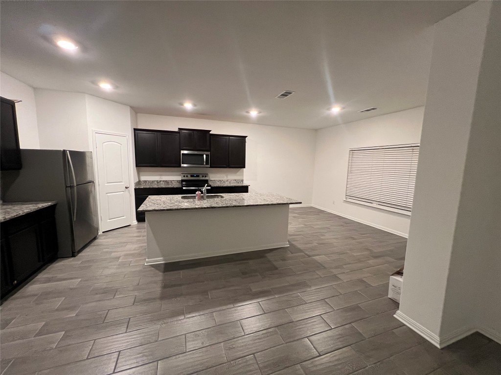 18413 Quiet Range Drive Elgin, TX 78621 - Photo 2 of 4 a large kitchen with stainless steel appliances a large counter top and a stove