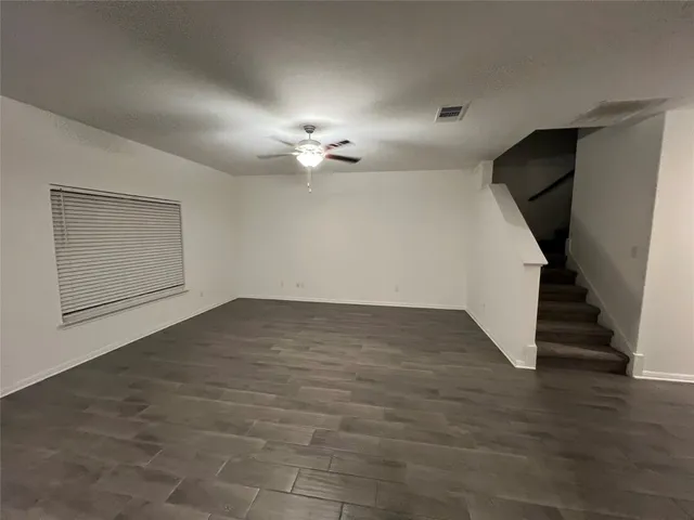 an empty room with wooden floor and staircase