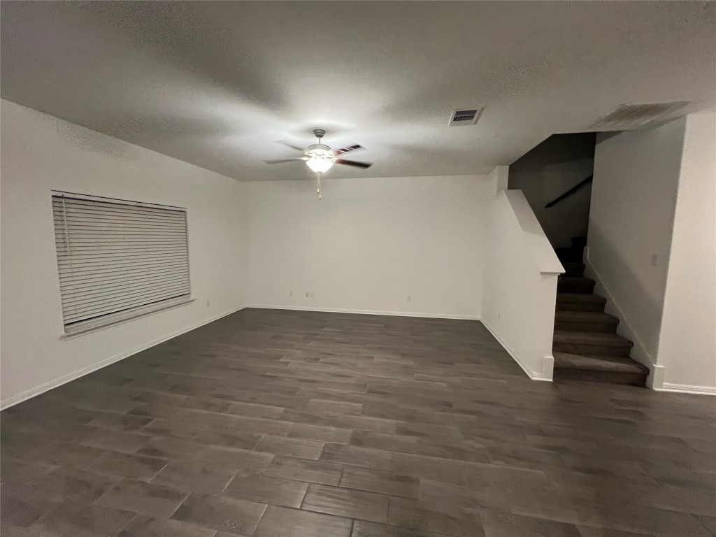 18413 Quiet Range Drive Elgin, TX 78621 - Photo 4 of 4 an empty room with wooden floor and staircase