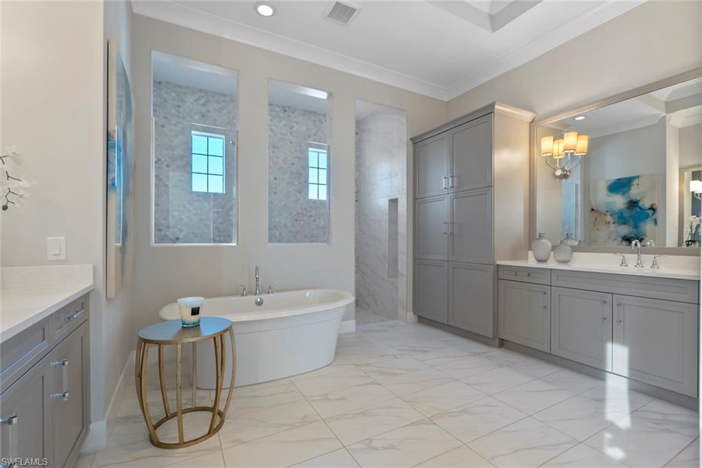 6250 Lightbourn Way Naples, FL 34113 - Photo 24 of 40 a bathroom with a tub sink and mirror