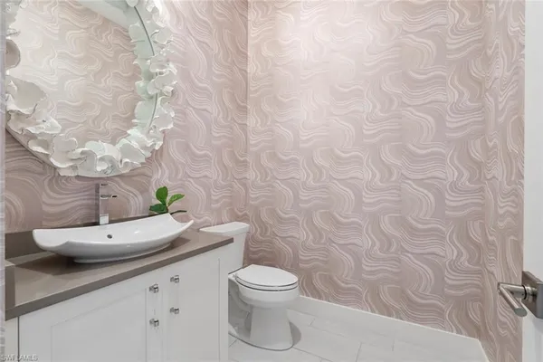 a bathroom with a granite countertop toilet and a sink