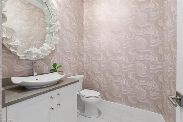 a bathroom with a granite countertop toilet and a sink