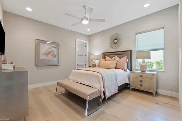 a bedroom with a bed chandelier and a window