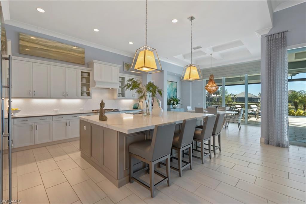 6250 Lightbourn Way Naples, FL 34113 - Photo 7 of 40 a kitchen with center island and stainless steel appliances
